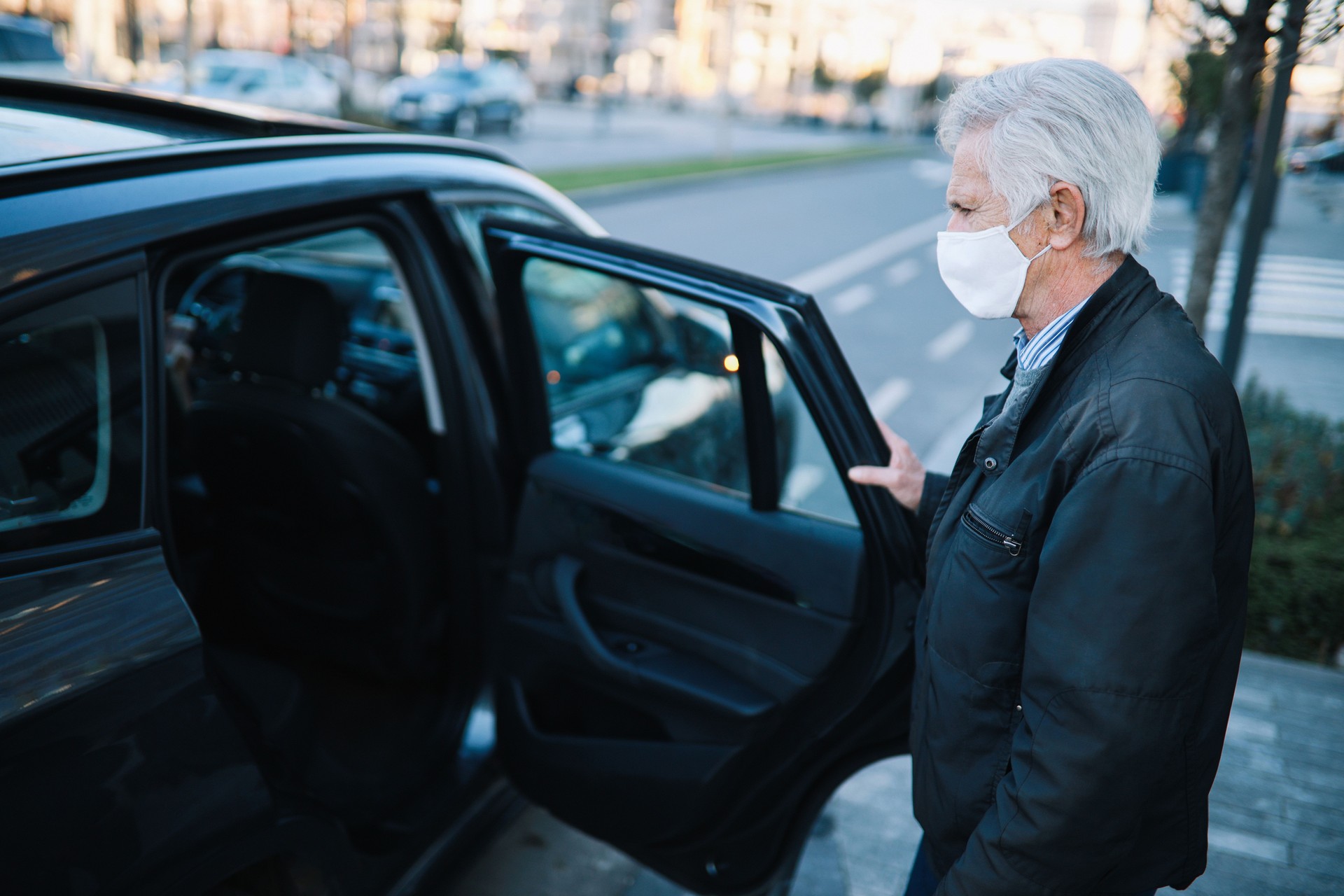 Senior man taking a rideshare in times of the pandemic